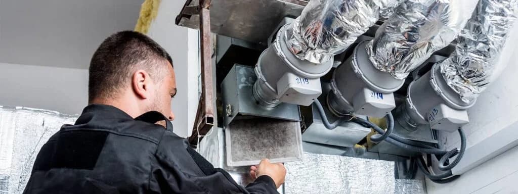 Male technician installing ductwork.