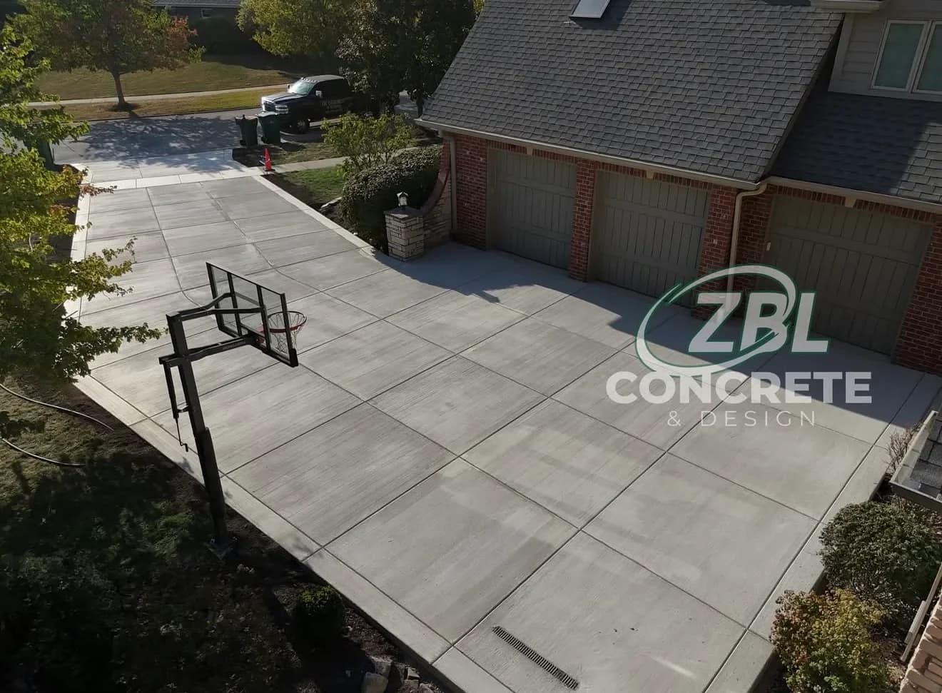 Large concrete driveway with basketball court in Lockport IL by ZBL Concrete & Design