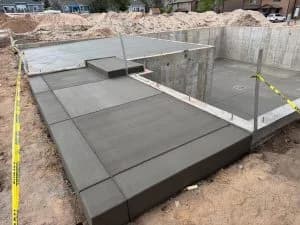 Concrete patio with foundation and basement with yellow tape to cures in daytime