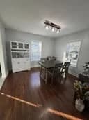 Formal dining room with white wainscoting, dark hardwood floors, and natural light from tall windows painted by OVO Painting in Atlanta
