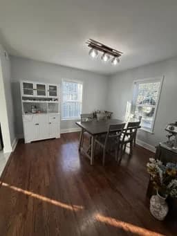 Formal dining room with white wainscoting, dark hardwood floors, and natural light from tall windows painted by OVO Painting in Atlanta