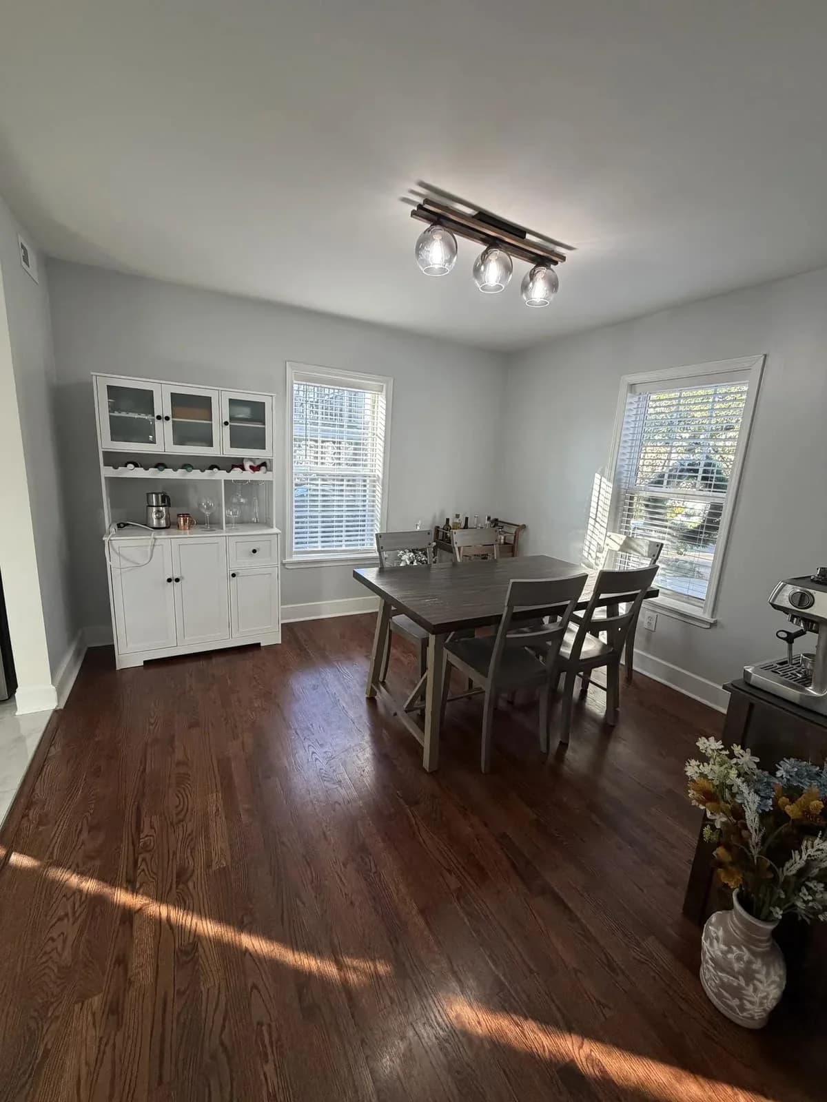 Formal dining room with white wainscoting, dark hardwood floors, and natural light from tall windows painted by OVO Painting in Atlanta
