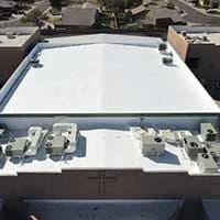 female commercial roofing technician is taking a roof core to determine the condition