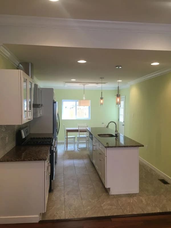Amenities in new kitchen include large island and pendant lighting
