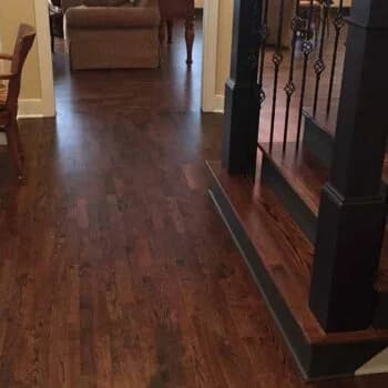 A hallway and staircase with beautifully installed dark hardwood flooring, showcasing the craftsmanship of Orange Cat Flooring in Atlanta, GA.