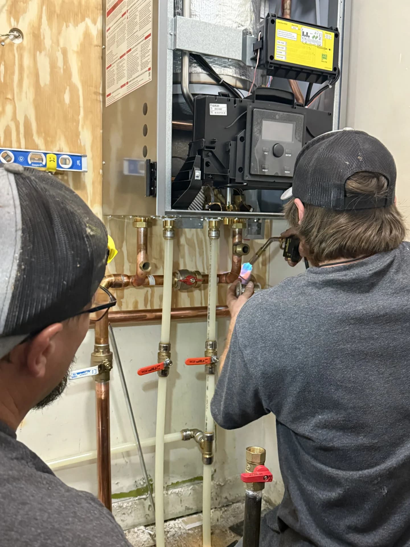 Professional HVAC technicians installing a new boiler unit in a Denver home for reliable, energy-efficient heating