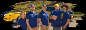 Malone Painting team standing in front of company trucks, smiling and wearing branded polo shirts