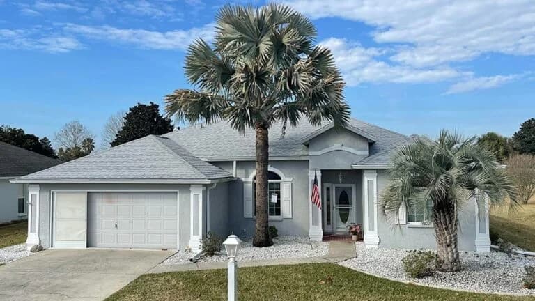 Light gray house with palm trees.