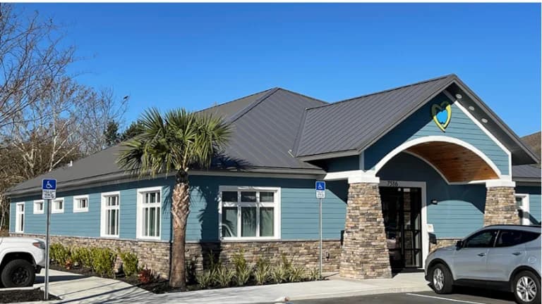 Light blue building with palm tree facade.