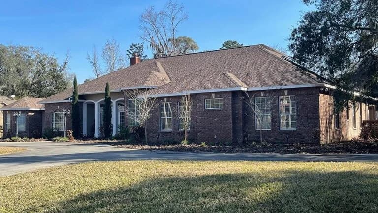 Brick house with landscaped yard and driveway.