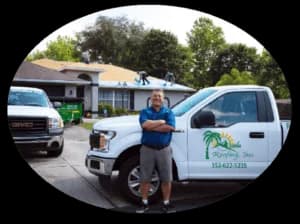 Roofing contractor stands by work truck.