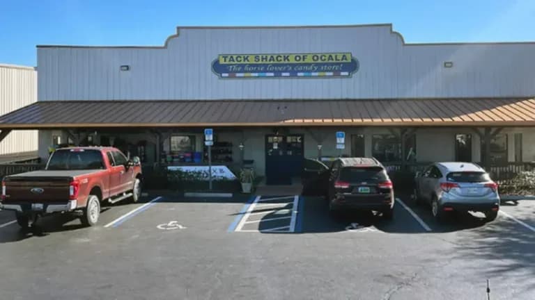 Tack Shack storefront with parked cars outside.