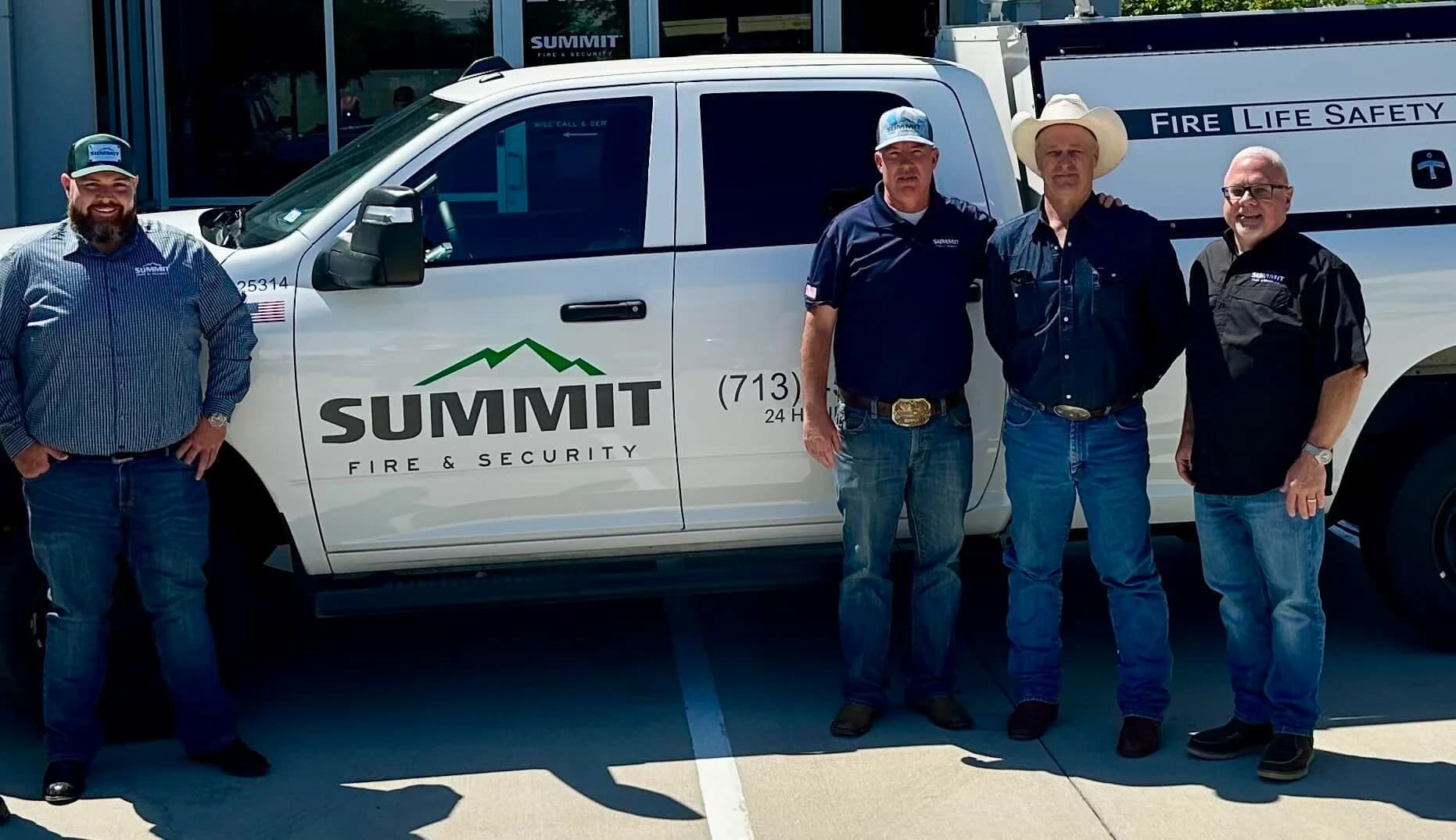 Employees standing next to Summit Fire & Security truck