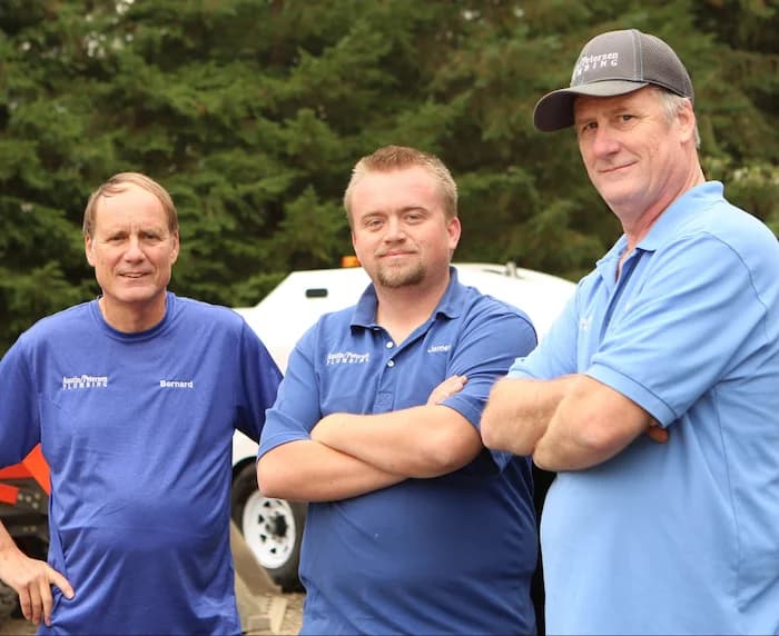 Three Petersens standing in front of plumbing equipment.