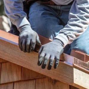 Worker fixes flashing as part of home inspection repairs